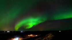 Ramalazos de auroras sobre alojamientos en el lago Myvatn