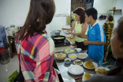 Personas cocinando y sirviendo comida en una cocina hogareña  