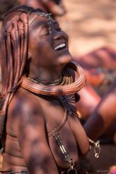 Mujer de la tribu Himba riendo bajo la luz del sol  